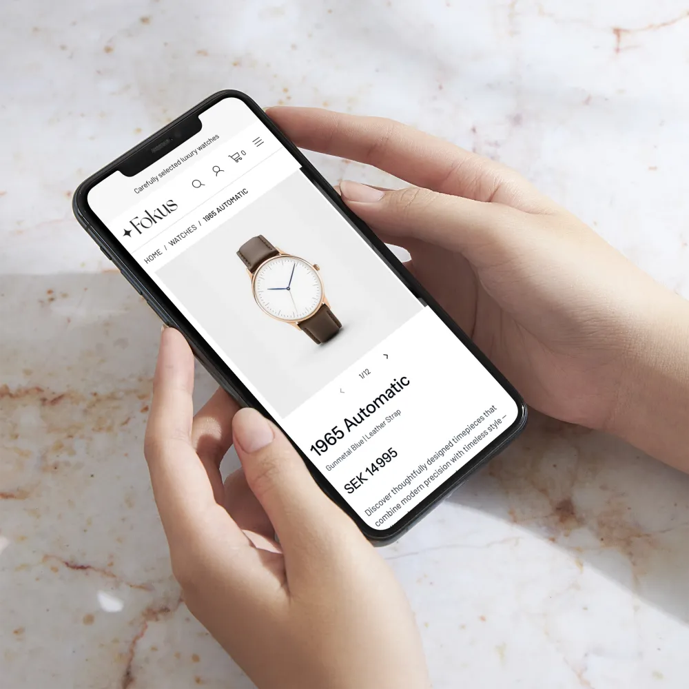 A person holding a smartphone and browsing a watch webshop – an example of user-friendly UI design created by Enode.