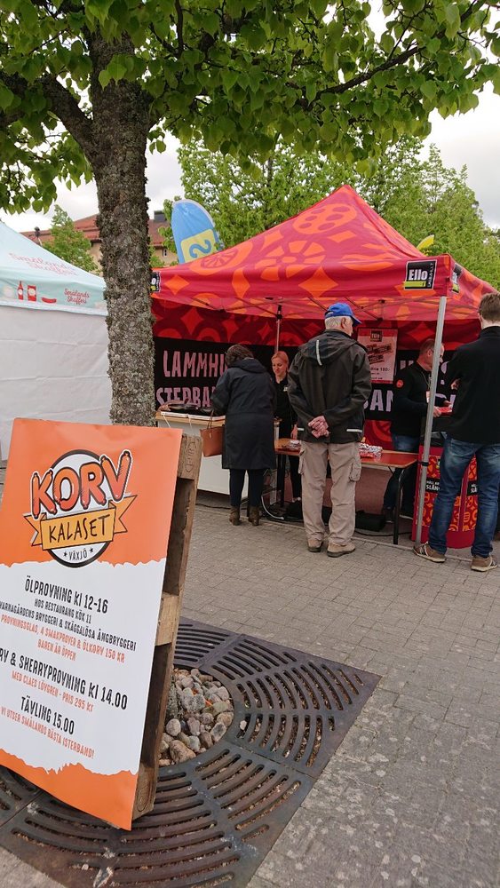 Bild på Ellos monter. I tältet står medarbetare från Ello och grillar isterband. 