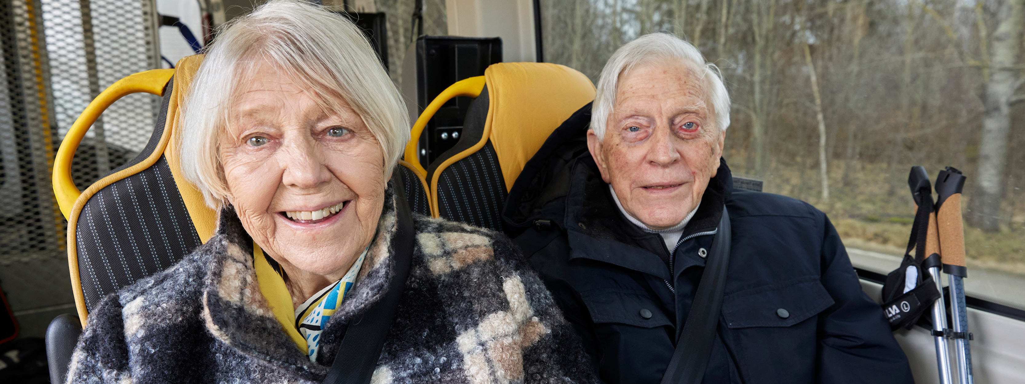 Ett äldre par sitter i en minibuss.