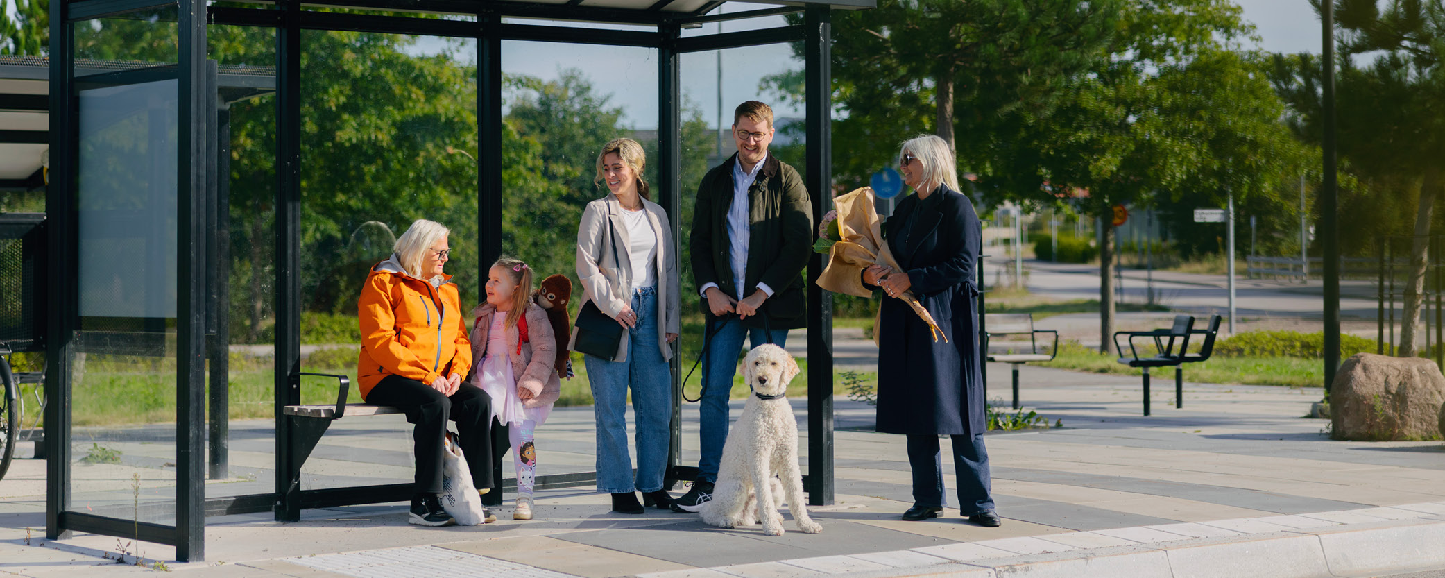 Människor står och väntar vid en hållplats.