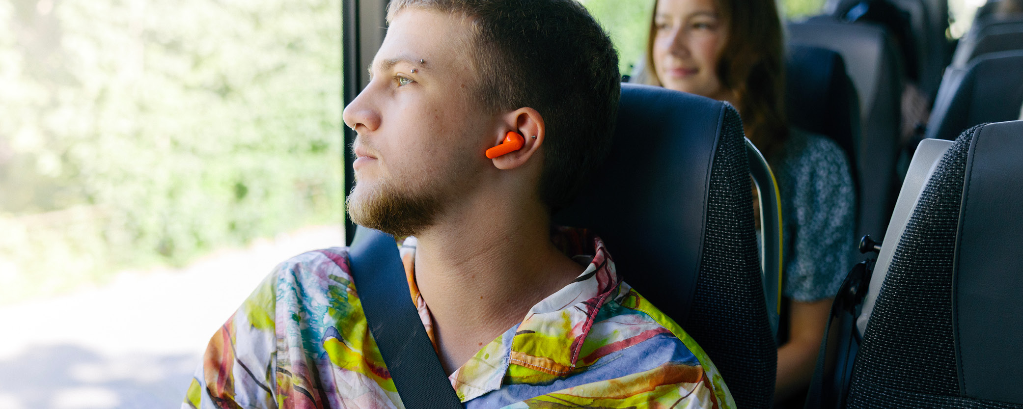 Kille tittar ut genom fönstret på en buss. 