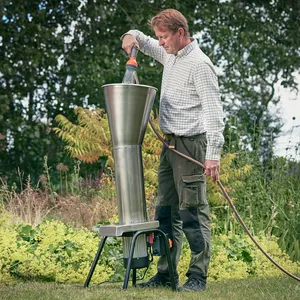 En man stående i trädgården och rengör fruktkrossen