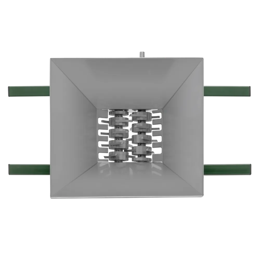 Fruktkross i rostfritt stål med gröna detaljer från ett perspektiv ovanifrån där tratten och krossvalvarna är i fokus