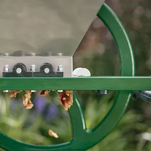 Krossade äpplen kommer ut från krossvalvarna i den manuella fruktkrossen från ett sidoperspektiv