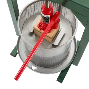 Cylinderformad hydraulisk fruktpress med detaljer i grönt, rött och trä från ett perspektiv ovanifrån