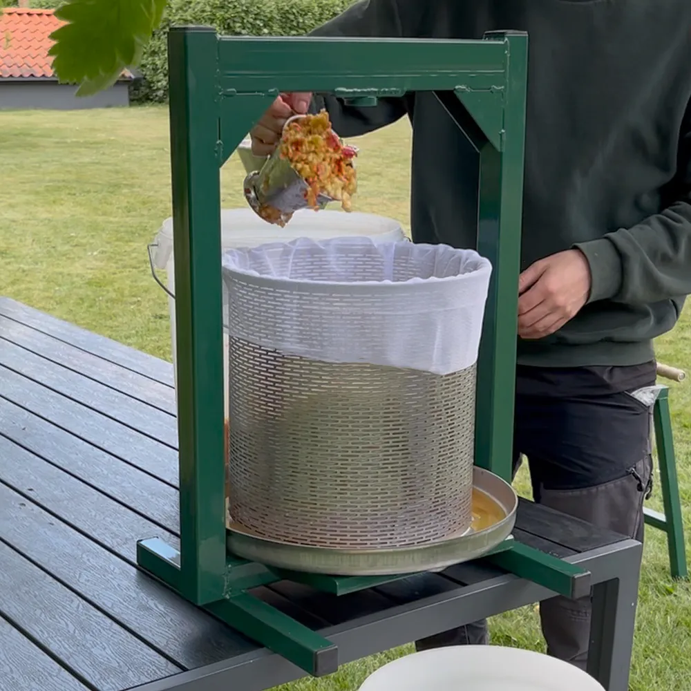  Hydraulisk Fruktpress 23L fylls med äppelkross, redo att bli must