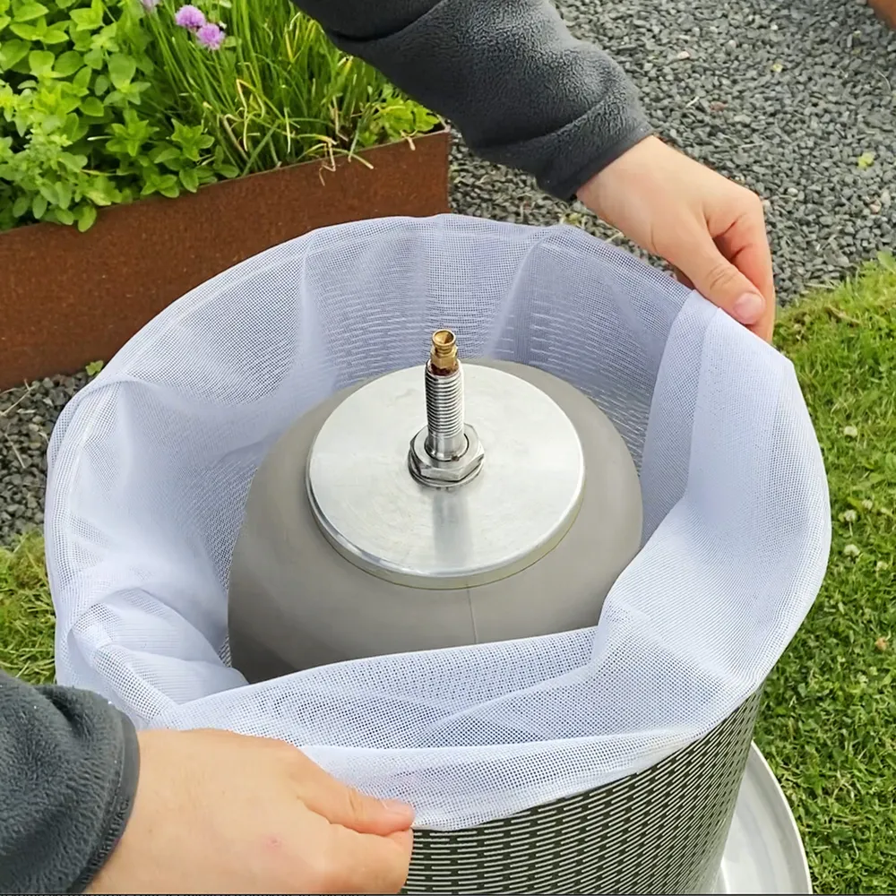 Man placerar ett filter i den cylindriska presskorgen till hydropressen