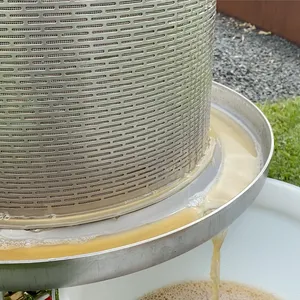 Ferdig juice renner ned fra hydropressen og ned i en bøtte
