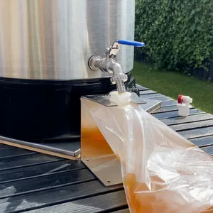 Varm äppelmust rinner ut ur tappkranen på pastören och fyller en 3 liters BIB påse 