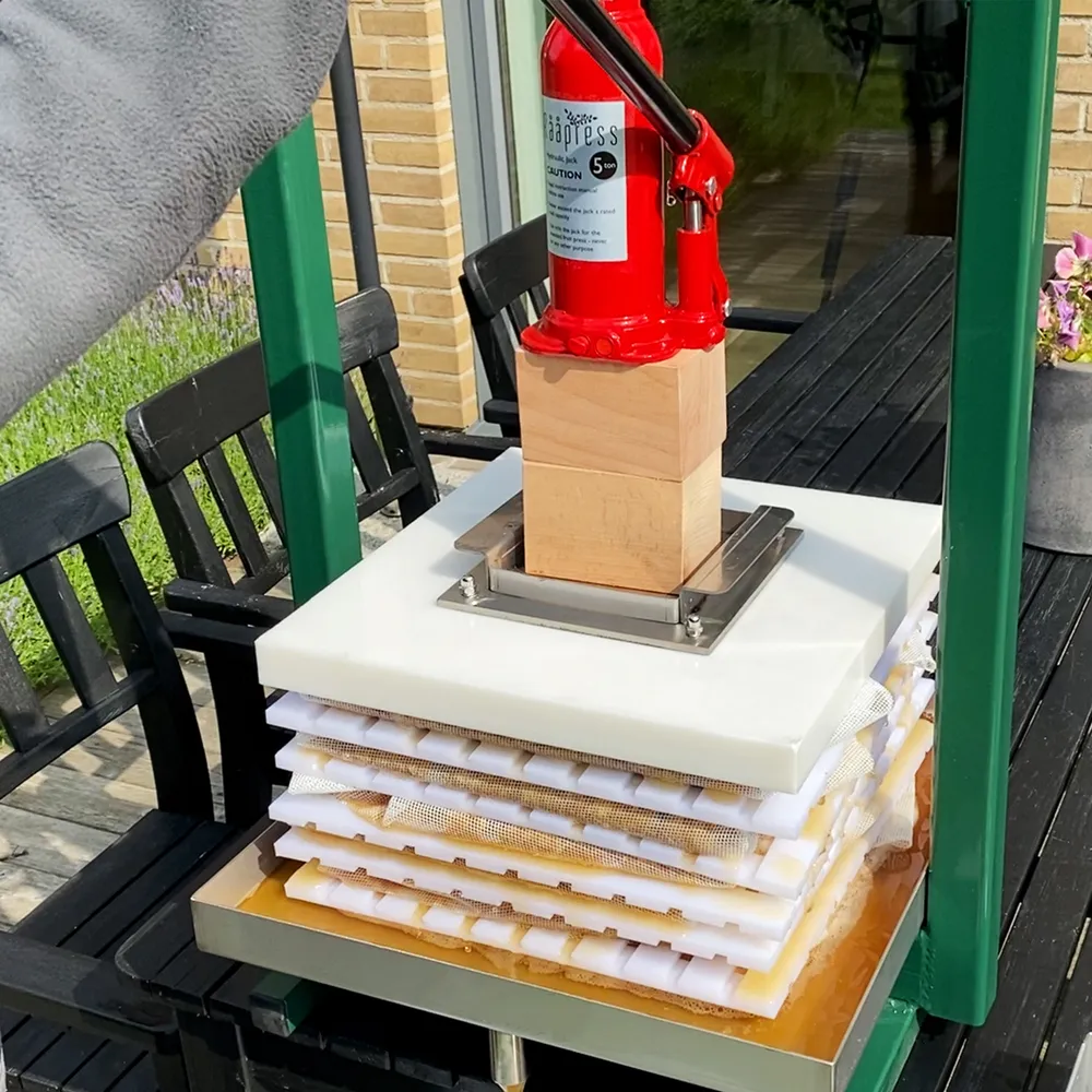 Hydraulisk packpress med tillhörande domkraft pressar fruktkross till must