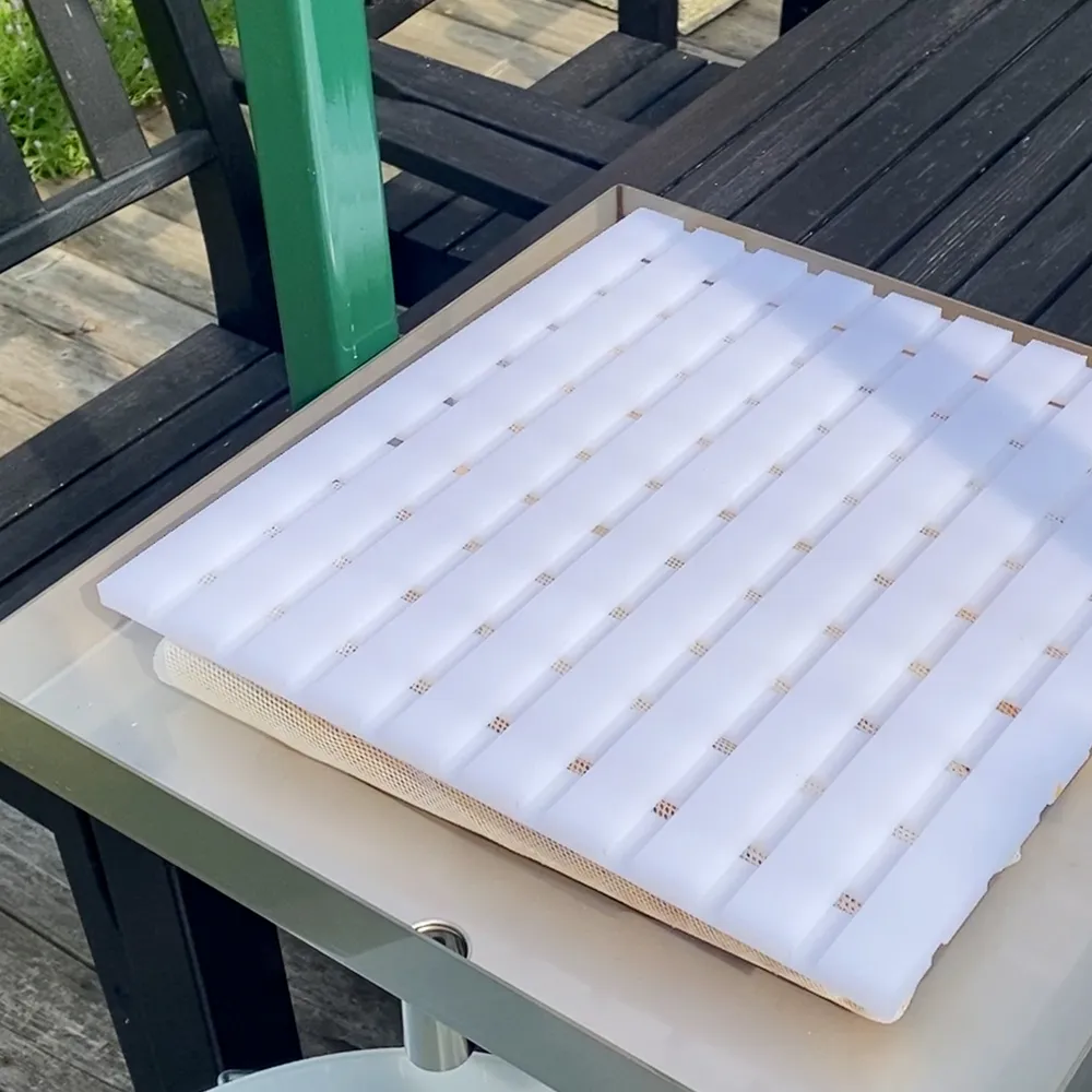 Ett lager pressplatta är placerad ovanpå packpressens uppsamlingsplatta