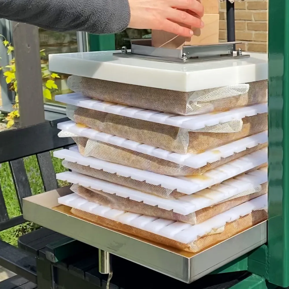 Träkloss placeras ovanpå den hydrauliska packpressen för att möjliggöra pressning av must med hjälp av en domkraft