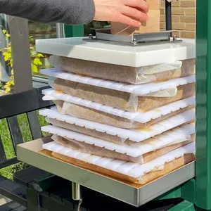 Träkloss placeras ovanpå den hydrauliska packpressen för att möjliggöra pressning av must med hjälp av en domkraft