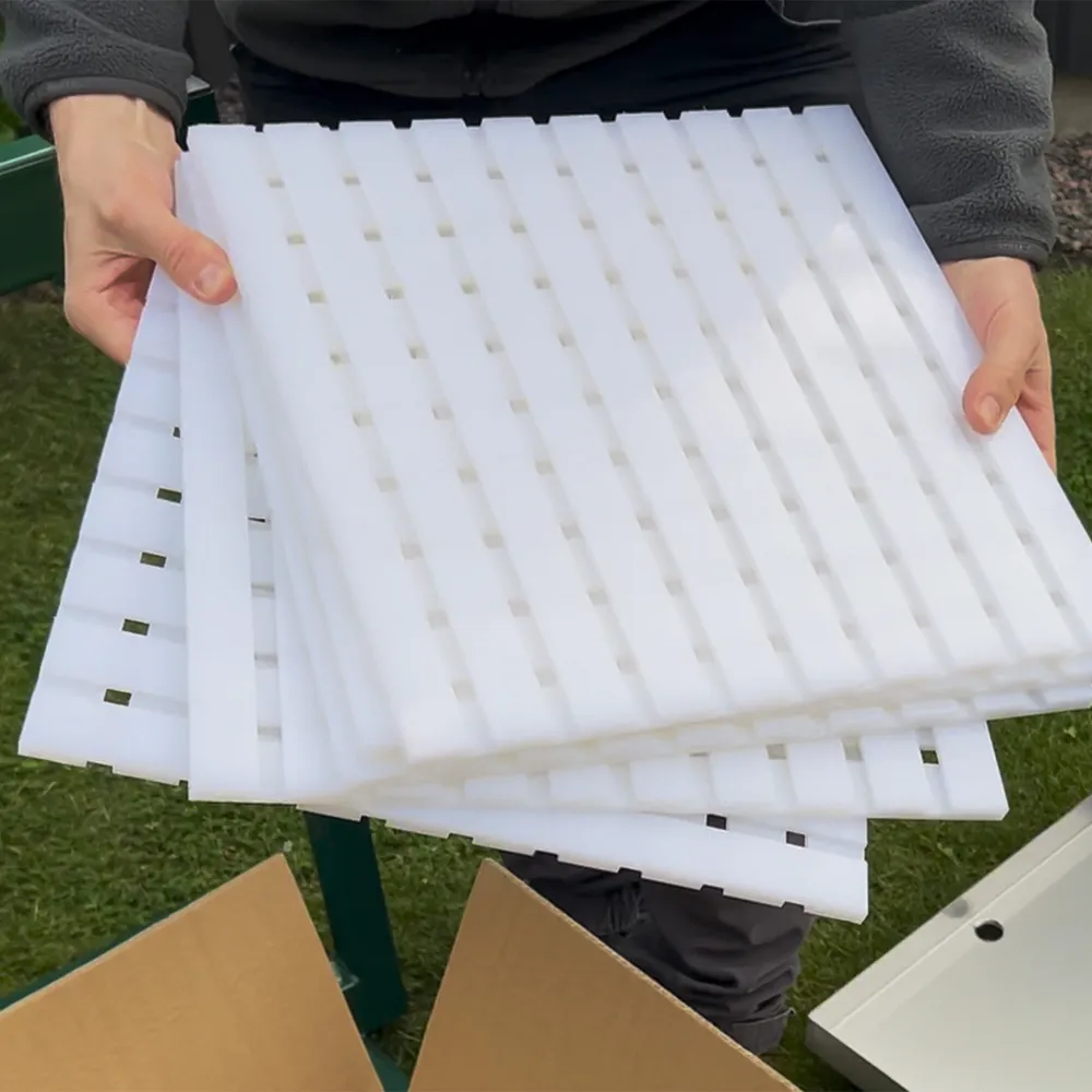 Närbild av vita pressplattor monterade i grönlackerad pressram