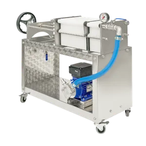Platefilter på et stativ i rustfritt stål med en blå slange koblet til en pumpe som står på stativet under platefilteret