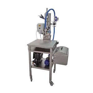 Maskinen sytår på ett bord av rostfritt stål med svängbara hjul, på bordets hylla sitter kompressor och pump kopplat till maskinen.