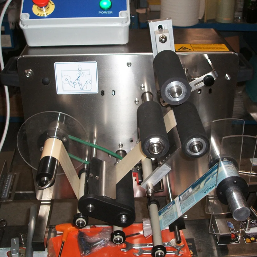 Etiketten placeres i en halvautomatisk mærkningsmaskine