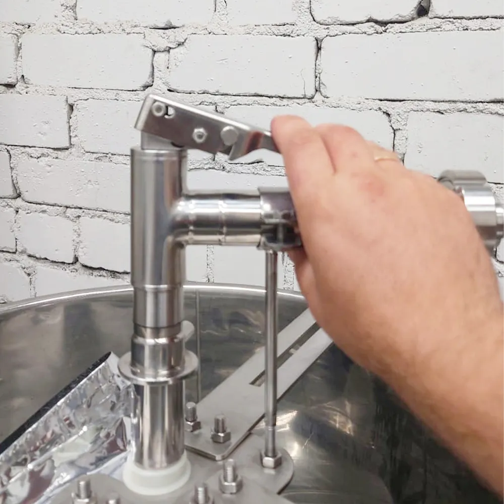 Hand som använder fyllningsutrustningen i rostfritt stål