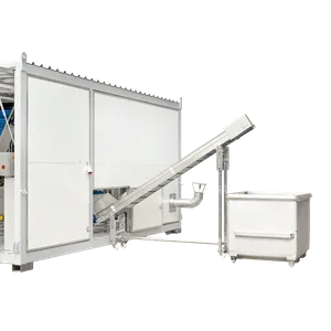 Skruetransportøren kaster ut rester fra juiceproduksjonen fra baksiden av containeren