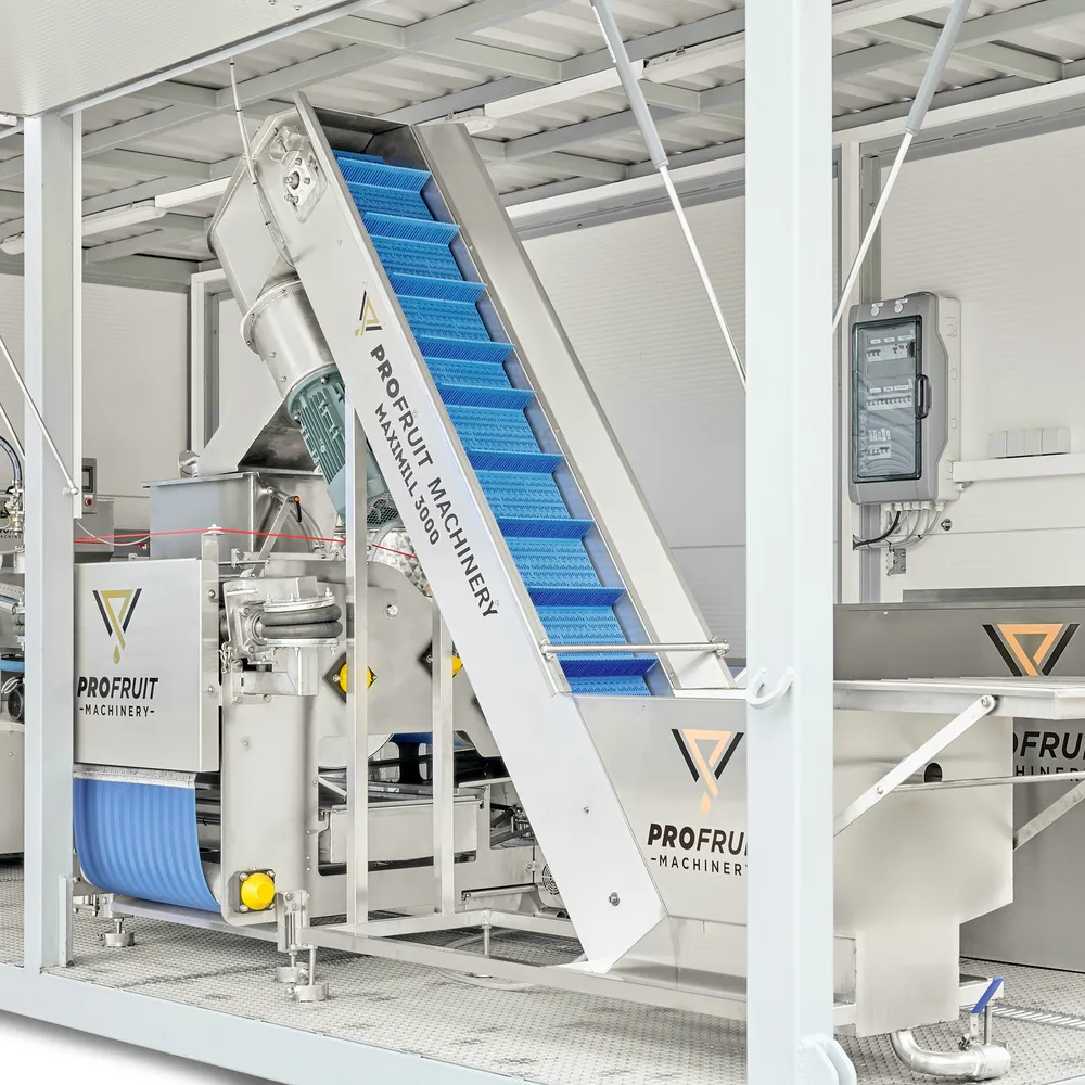 I den andre enden av containeren er det en kombinert vaskemaskin-knuser-transportør som er lett tilgjengelig for lasting av epler.