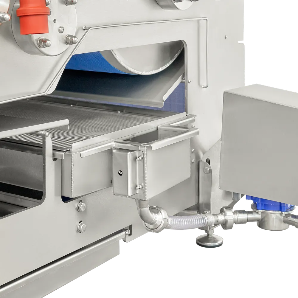 Hihnapuristimen alla oleva keräyslaatikko, johon on kiinnitetty pumppu