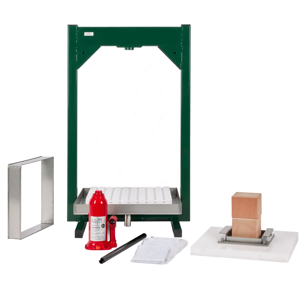 Hydraulisk fruktpresse med presseramme, hvite presseplater, treklosser og rød jekk under montering