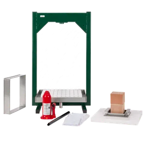 Hydraulisk fruktpress med pressram, vita pressplattor, träklossar och röd domkraft under montering