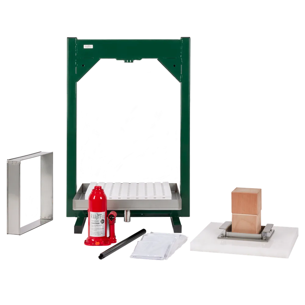 Hydraulisk fruktpresse med presseramme, hvite presseplater, treklosser og rød jekk under montering