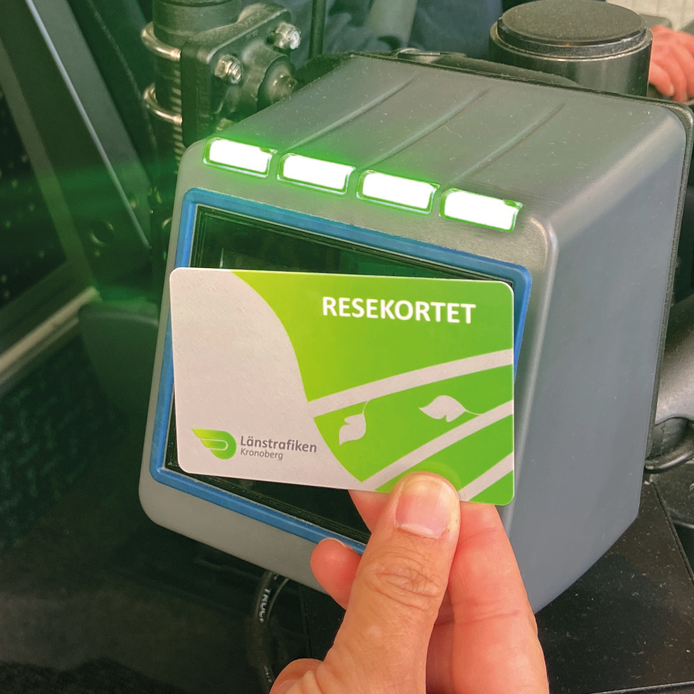 Ett reskort hålls mot en biljettläsare. Biljettläsaren lyser grönt.