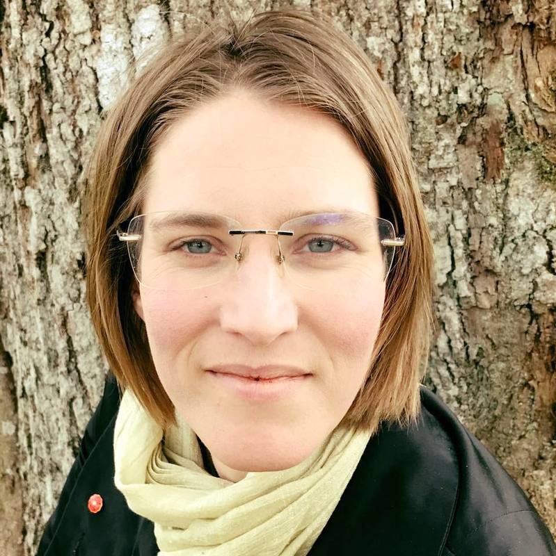 Projektledare Ingela Eriksson i grön sjal och svart jacka framför ett träd.