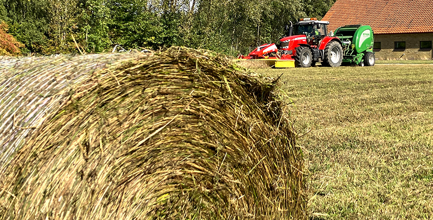 Foto på höbal och traktor.