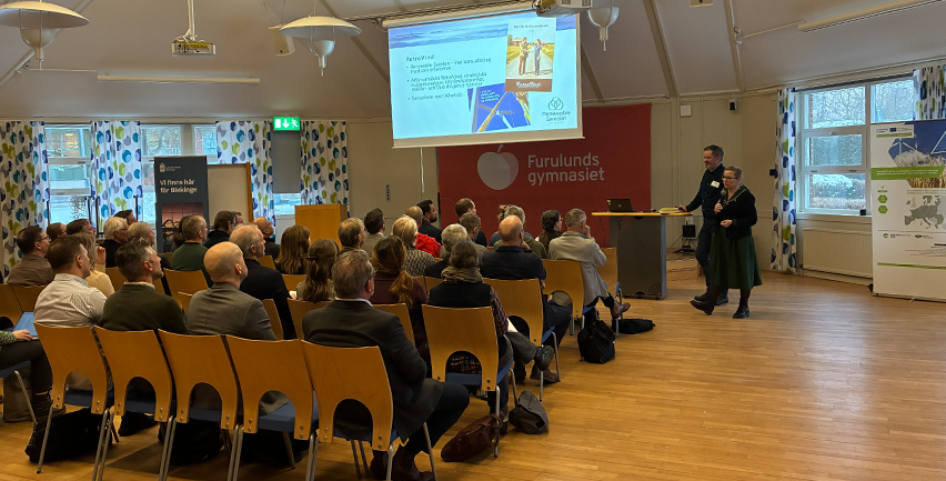 Sittande publik i en föreläsningssal. 