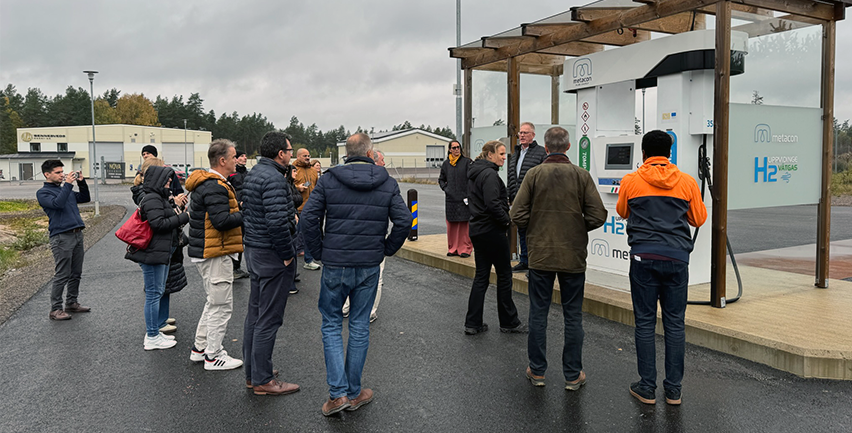 Människor samlade framför ett tankställe för vätgas.