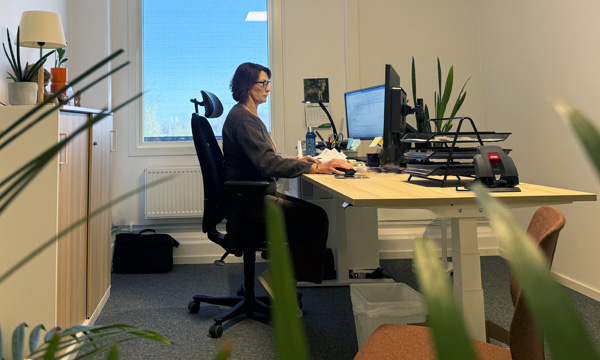 Bild på Helén vid sitt skrivbord på hennes nyrenoverade kontor på LVI Low Vision International i Växjö.