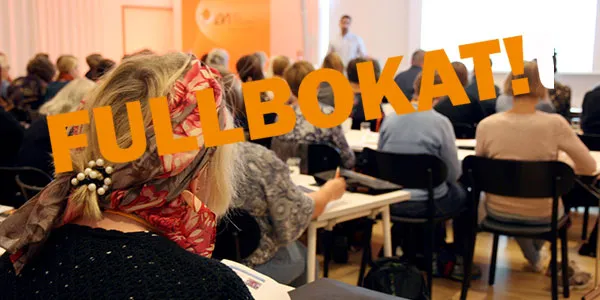 Bild från konferenssalen tidigare år, där man ser ryggar på deltagare. På bilden står texten Fullbokat!
