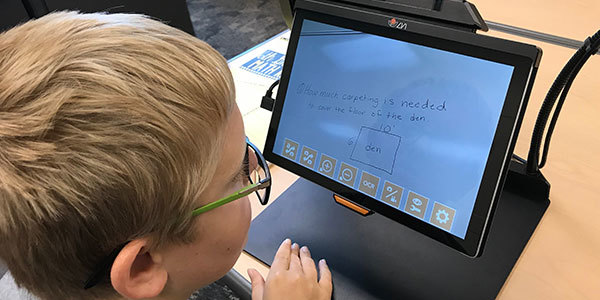 The boy Ethan uses a MagniLink TAB in school.