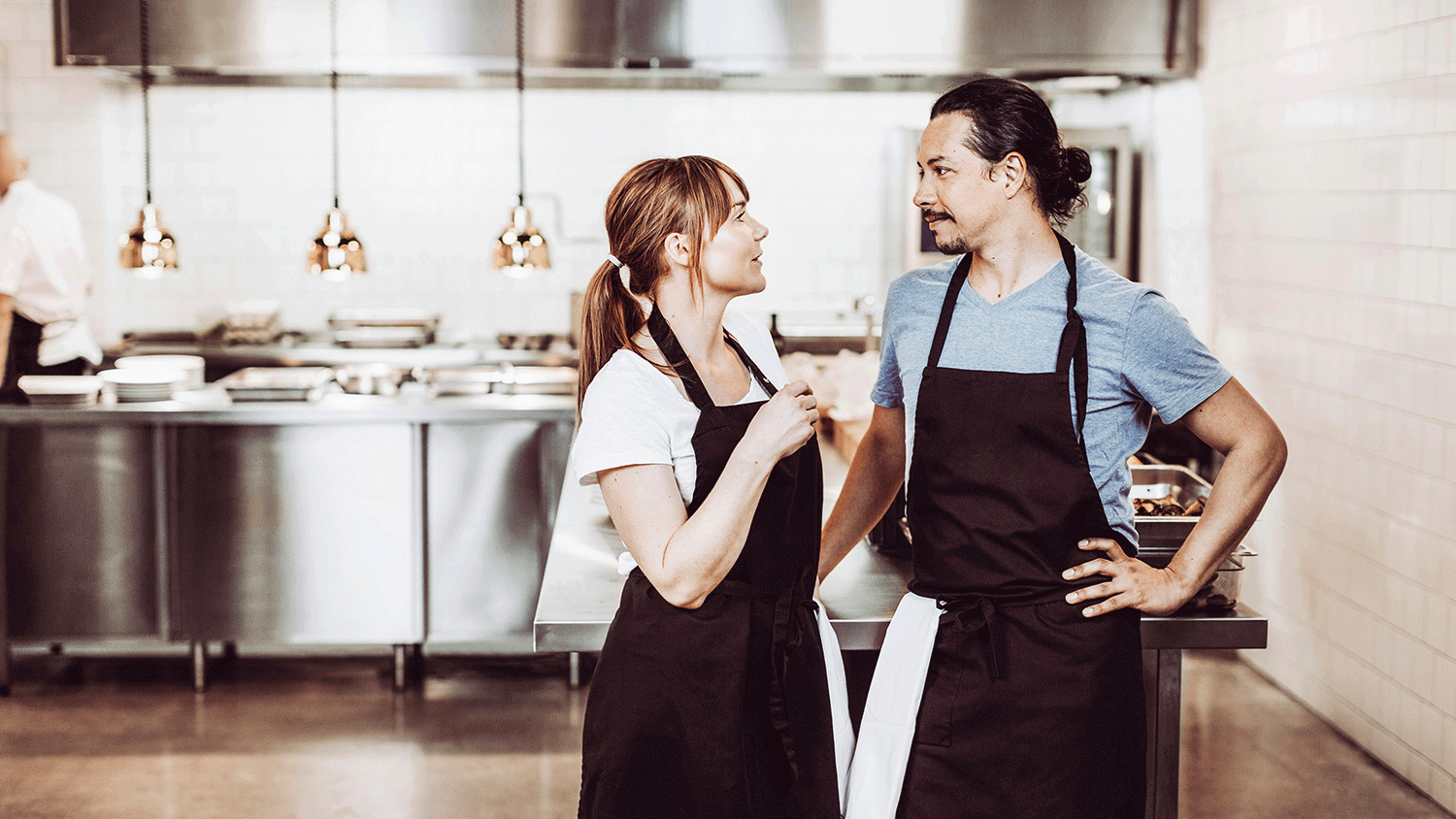 woman and man standing in catering kitchen