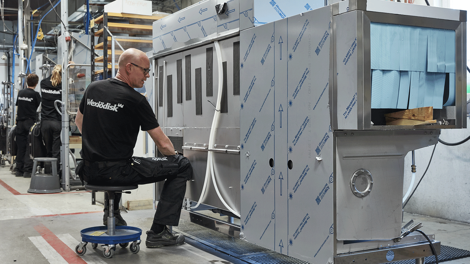 servicetekniker som arbetar på tvättmaskiner i fabrik